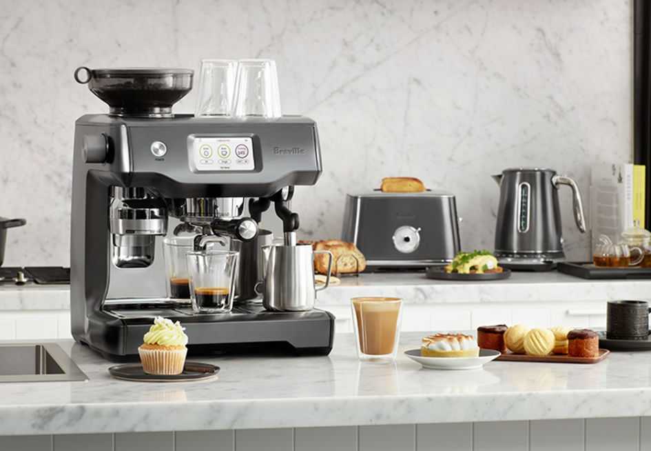 Display of a black stainless steel coffeemachine with various cakes.